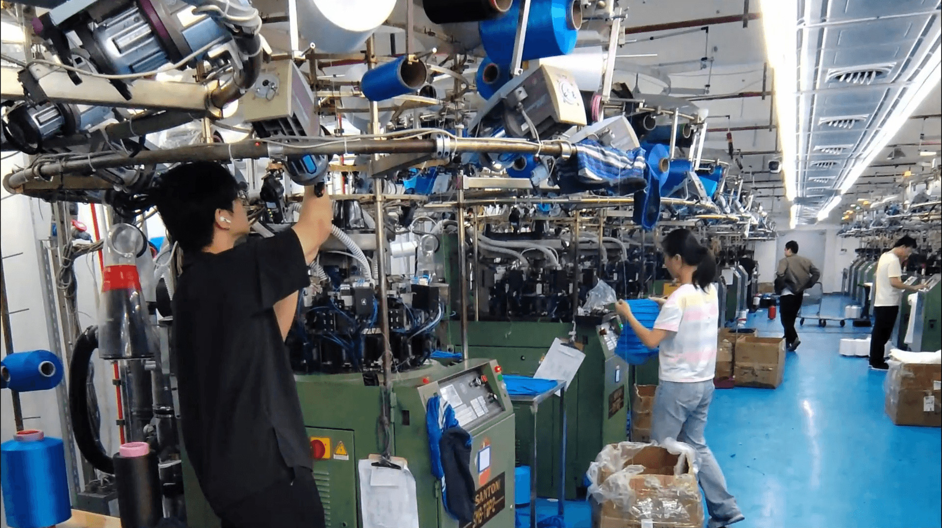 Operators working among seamless knitting machines in the Yiwu workshop